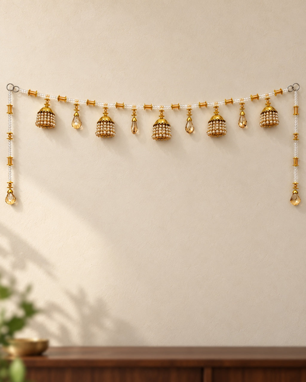 Sunehri Jhumka Drop Toran - full product on a cream wall