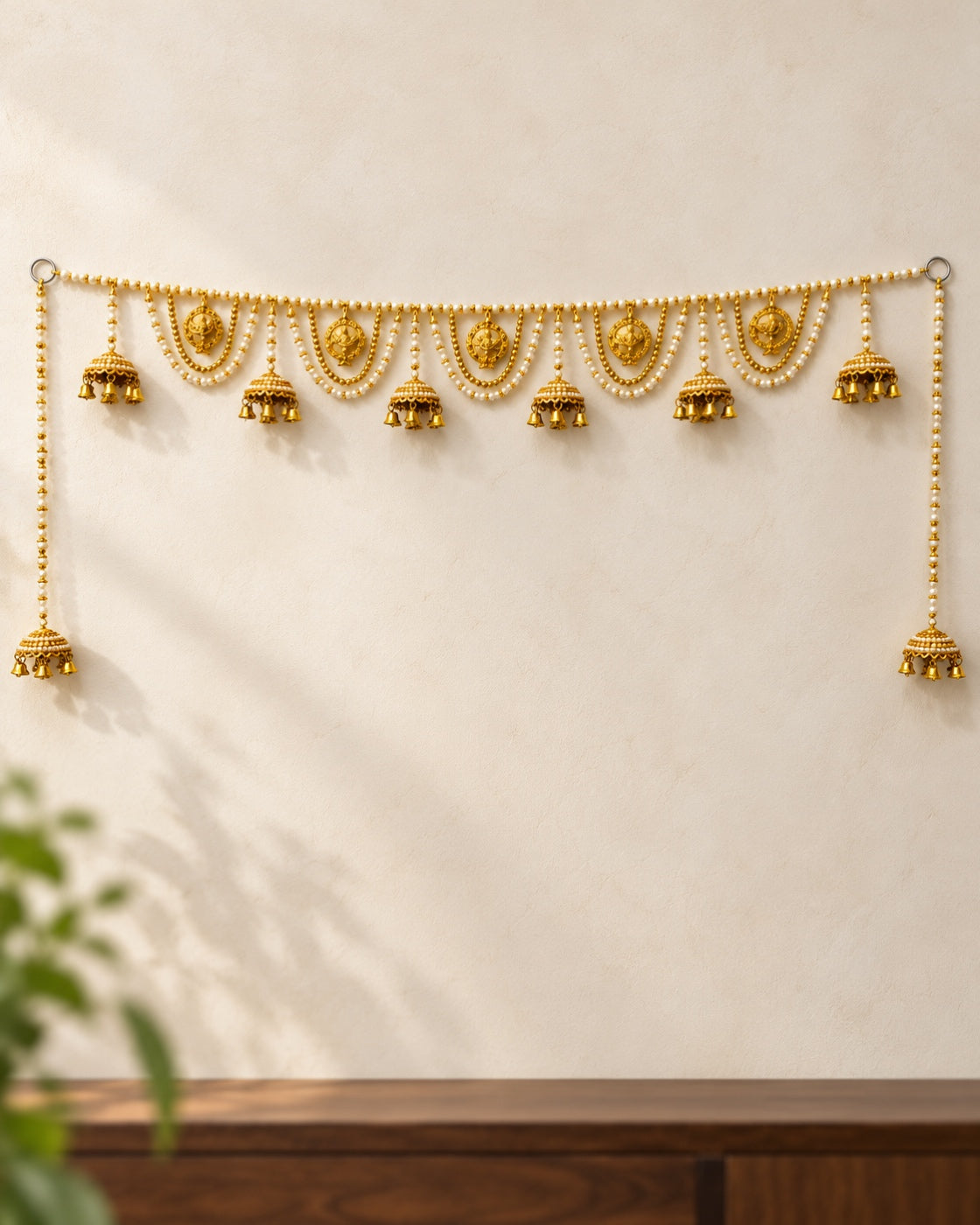 Sunehri Medallion Jhumka Toran - full product on a cream wall