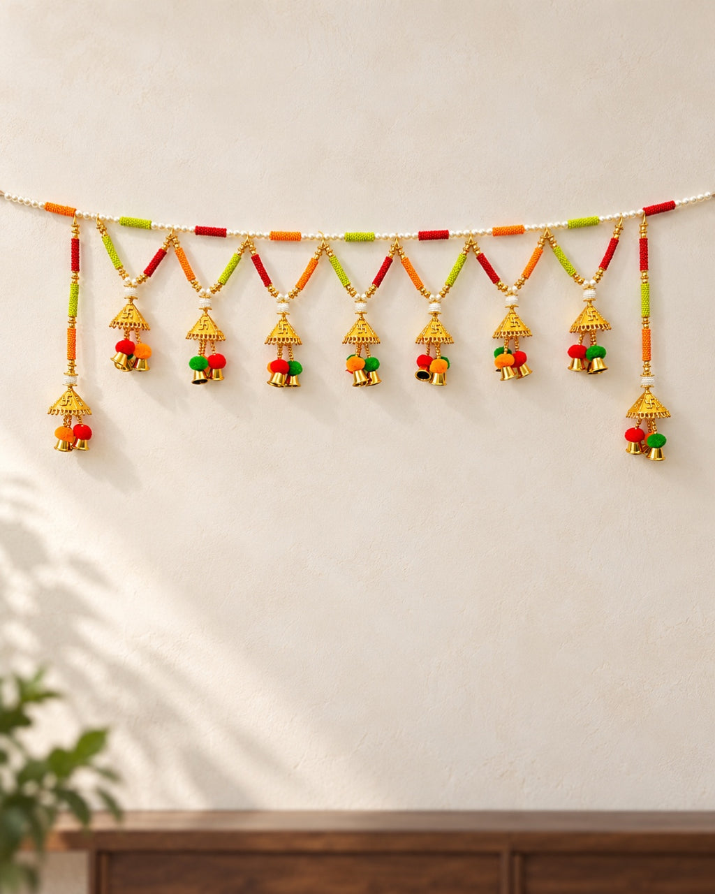 Rangoli Pom-Pom Bell Toran - full product on a cream wall