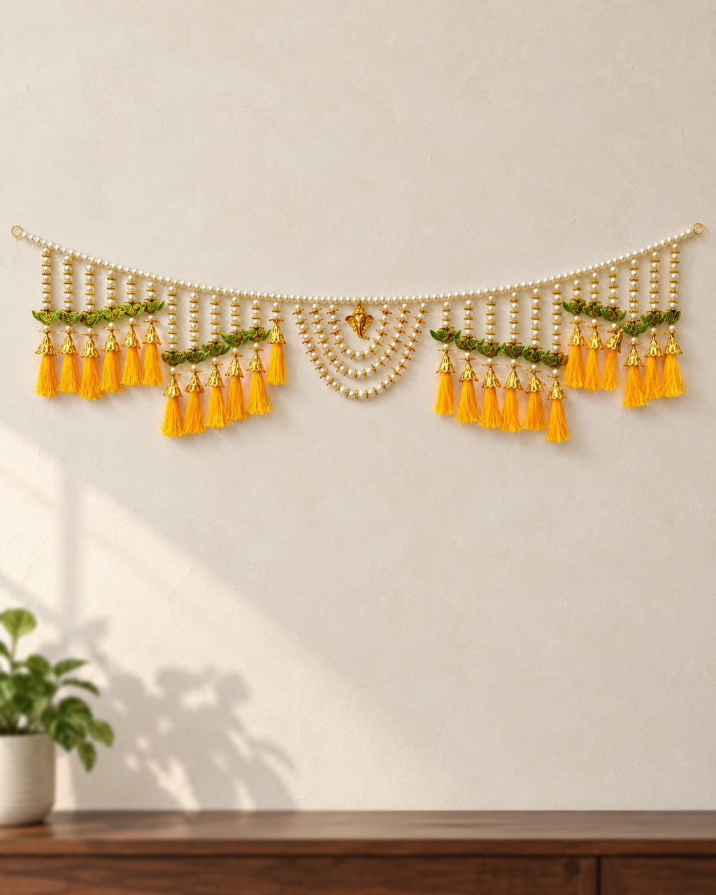 Peacock Yellow Tassel Toran - full product on a cream wall