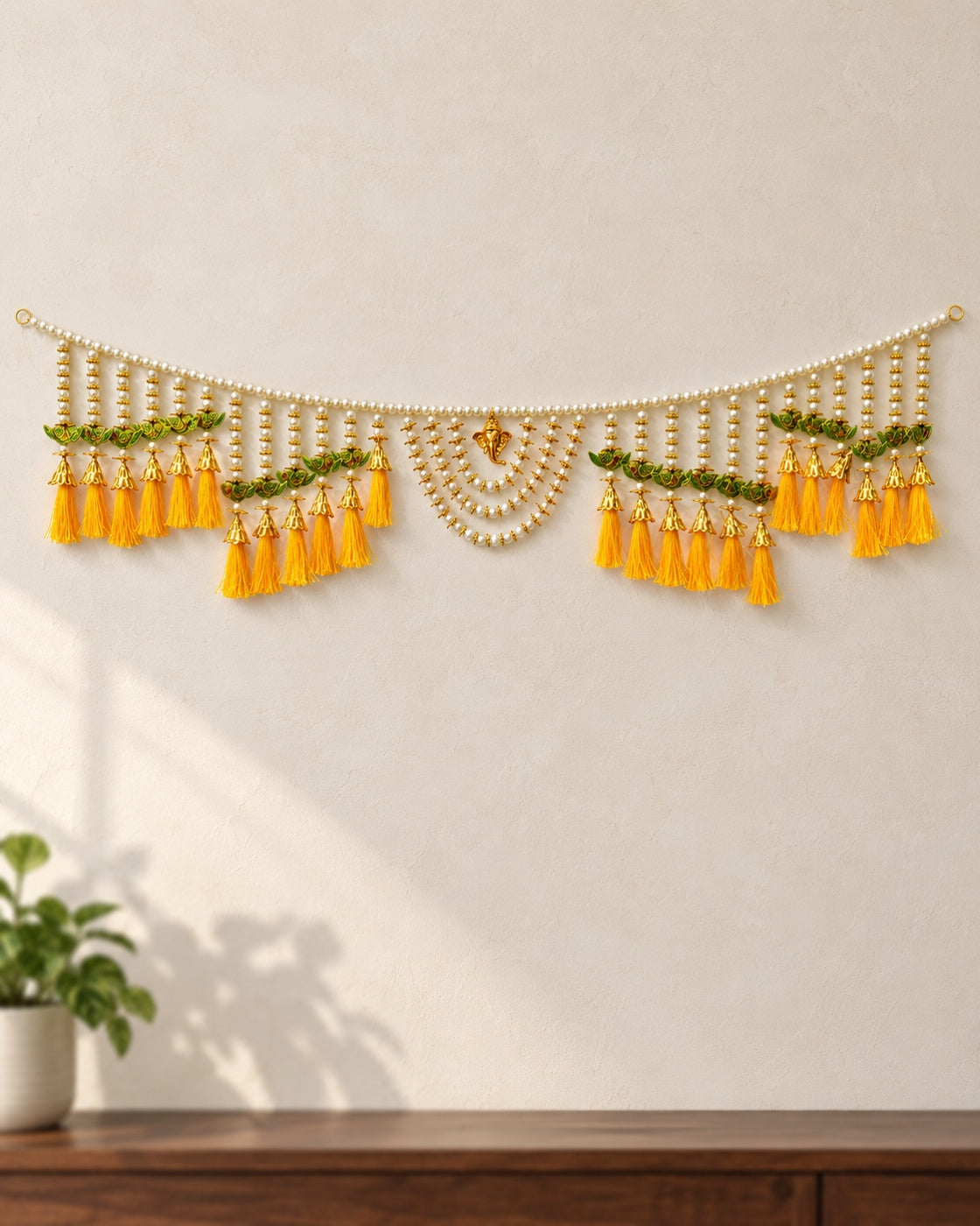 Peacock Yellow Tassel Toran - full product on a cream wall