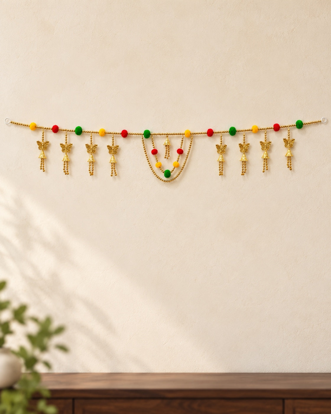 Butterfly Pom-Pom Toran - full product on a cream wall