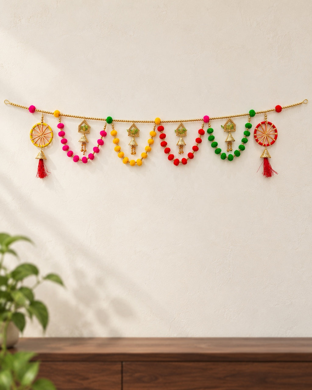 Peacock Chakra Pom-Pom Toran - full product on a cream wall